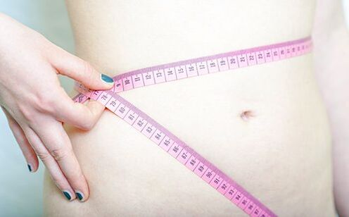 Una niña mide su cintura para registrar los resultados de la dieta Dukan